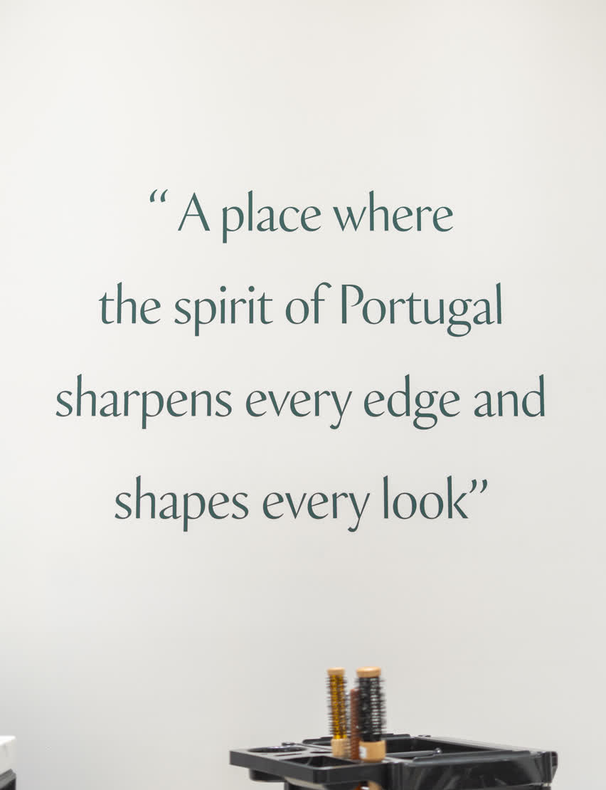 A wall quote inside A Barbearia Portuguesa reading 
